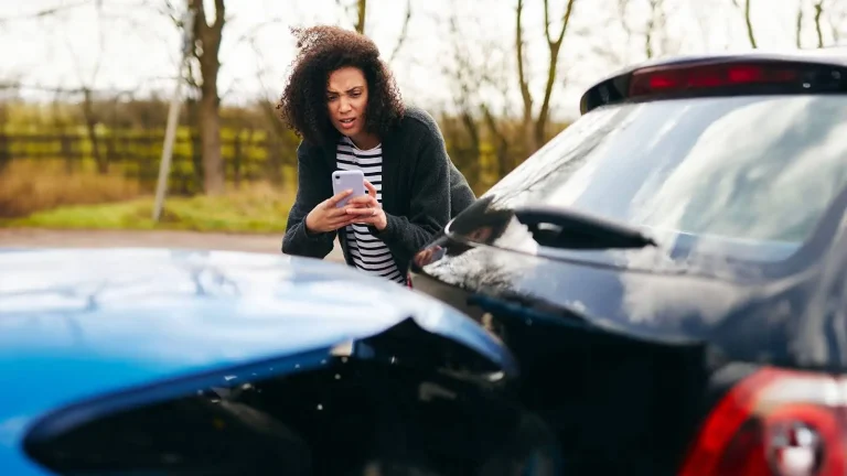 Woman taking photo of car accident